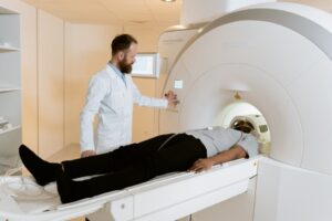 A doctor operates an MRI machine with a patient undergoing a scan in a medical facility.