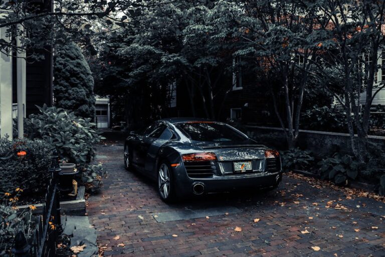 A sleek Audi R8 parked in a leafy residential driveway in Cape May, NJ, showcasing elegance and luxury.