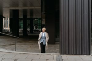 Confident businesswoman in formal wear standing outside modern office building.