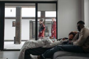 Paramedics assist a woman at home while her partner comforts her, emphasizing healthcare support.