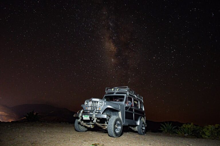 A rugged vehicle parked under the Milky Way in Real de Catorce, Mexico. Night sky filled with stars.