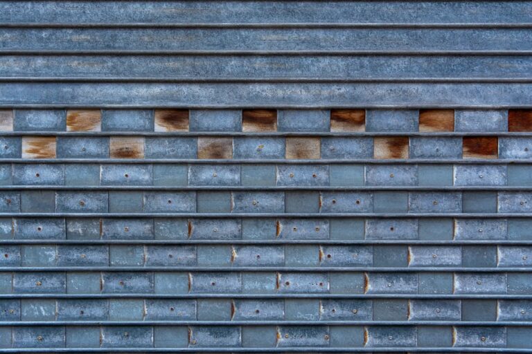 Close-up of a textured metal garage door with a unique brick-like pattern and weathered surface.