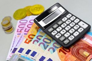 Image of euro banknotes, coins, and a calculator for financial planning. Perfect for finance themes.