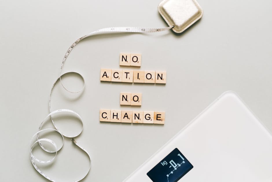 Motivational concept with scrabble tiles spelling no action no change alongside a measuring tape and scale.