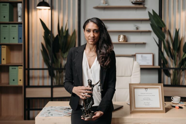 Confident woman lawyer holding a statuette in a modern office with diploma and paperwork visible.