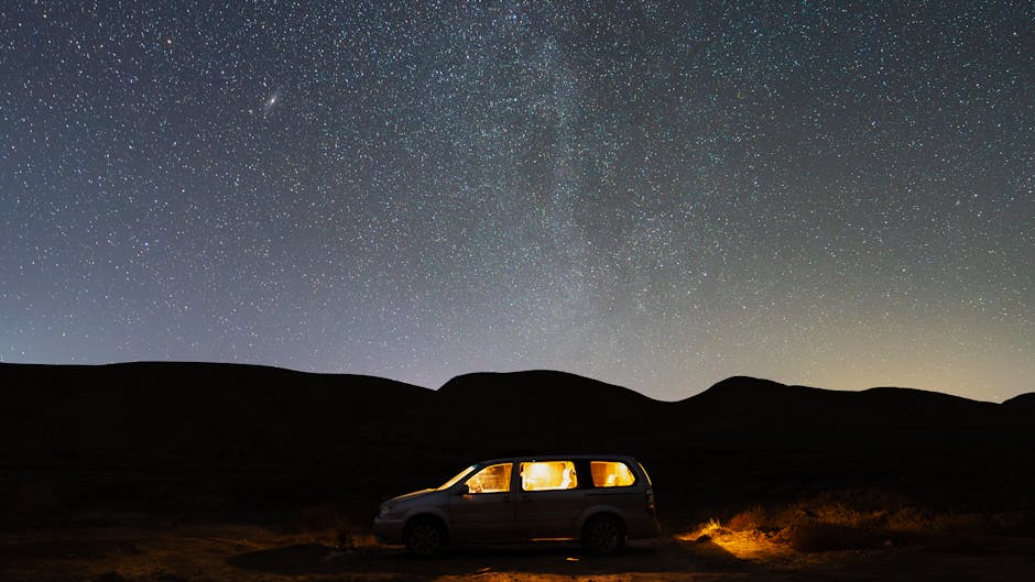 A peaceful desert scene with a glowing car under a vast starlit sky.