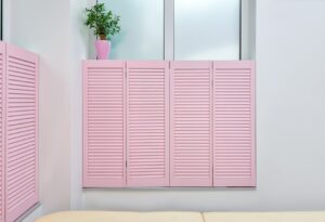 Minimalist interior of beauty office with couch for clients and pink shutters covering window
