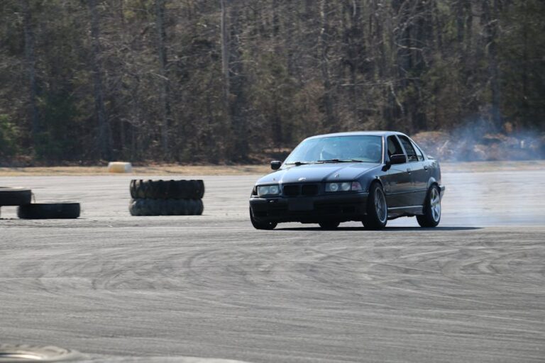 Dynamic shot of a car performing a high-speed drift on an outdoor track, leaving a trail of smoke.