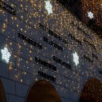 Building decorated with snowflake lights and strings of yellow fairy lights.