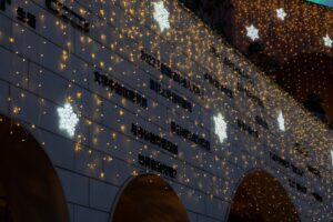 Building decorated with snowflake lights and strings of yellow fairy lights.