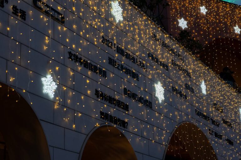 Building decorated with snowflake lights and strings of yellow fairy lights.