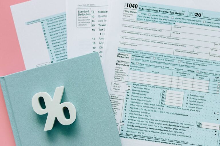 Tax documents with a percentage symbol on a pink and blue desk setup, emphasizing finance.