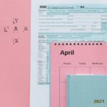Tax-related items on a pink background, including forms and a calendar.