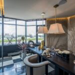 Elegant office space with modern design, featuring luxurious furniture and a scenic glass wall view.