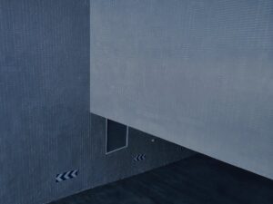 Abstract view of a contemporary grey facade with directional arrow marks on a textured wall.