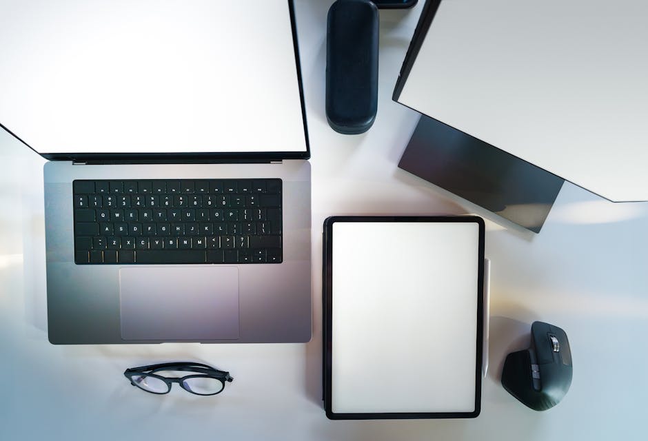 Top view of a sleek modern office desk with a laptop, tablet, and accessories.
