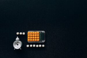 Flat lay of a tax season theme with a clock and calculator on a dark background.